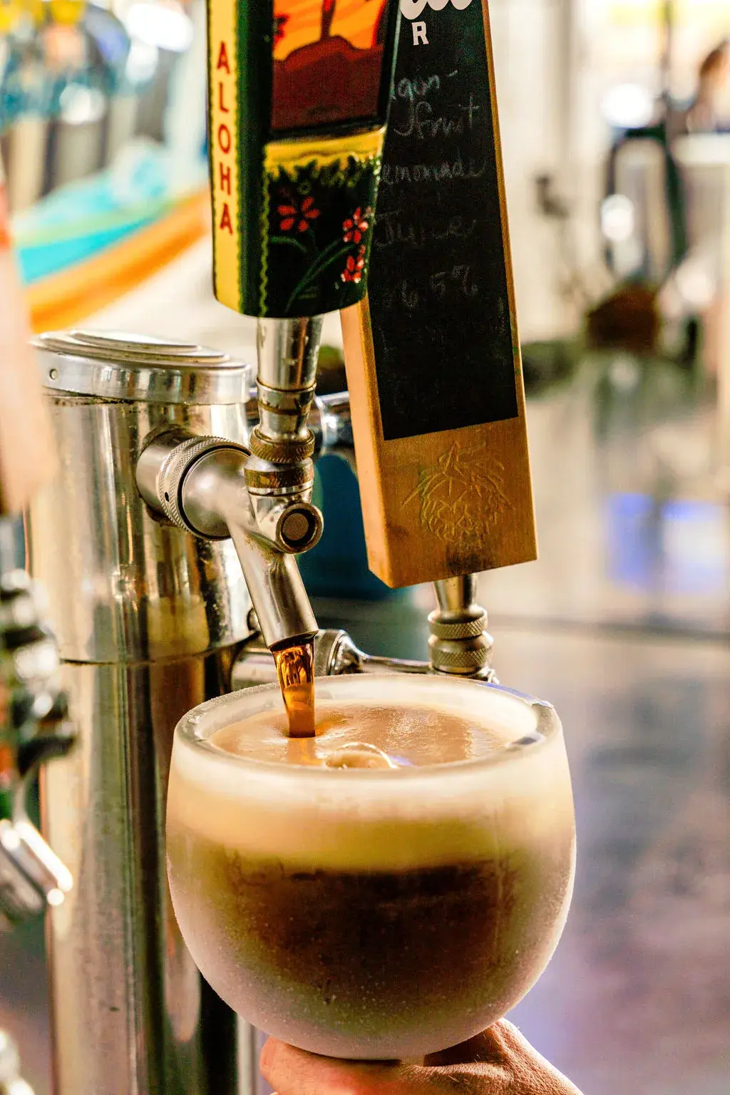 Ice-cold draft beer pouring into a chilled schooner during happy hour at Harbor House Kona